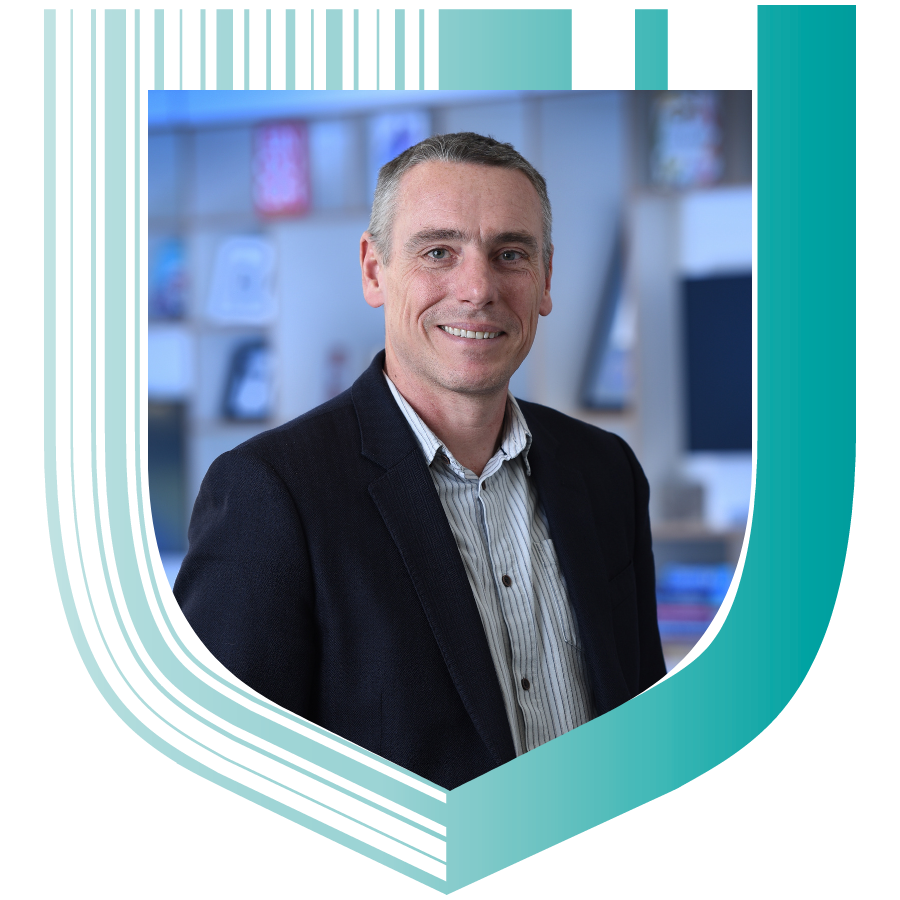Photograph of Ben Denne, Director of Publishing at Cambridge University Press, in a shield shape.