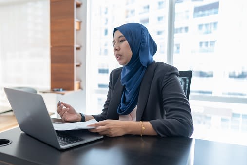 woman dressed smartly working at laptop in a city office