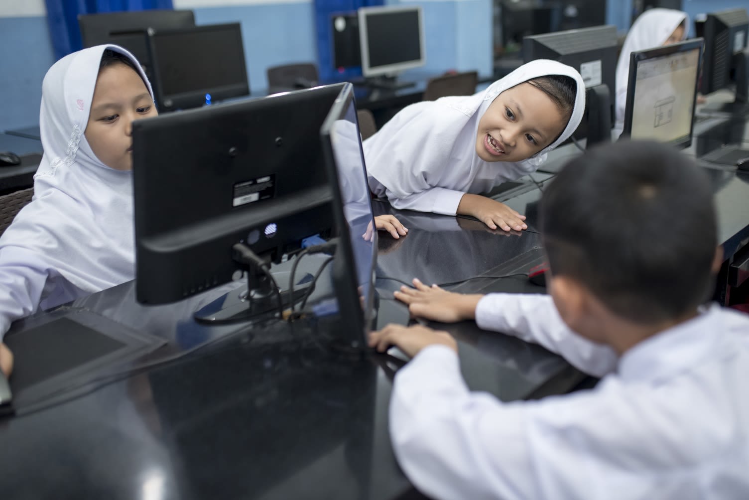young school children using tech in southeast Asia