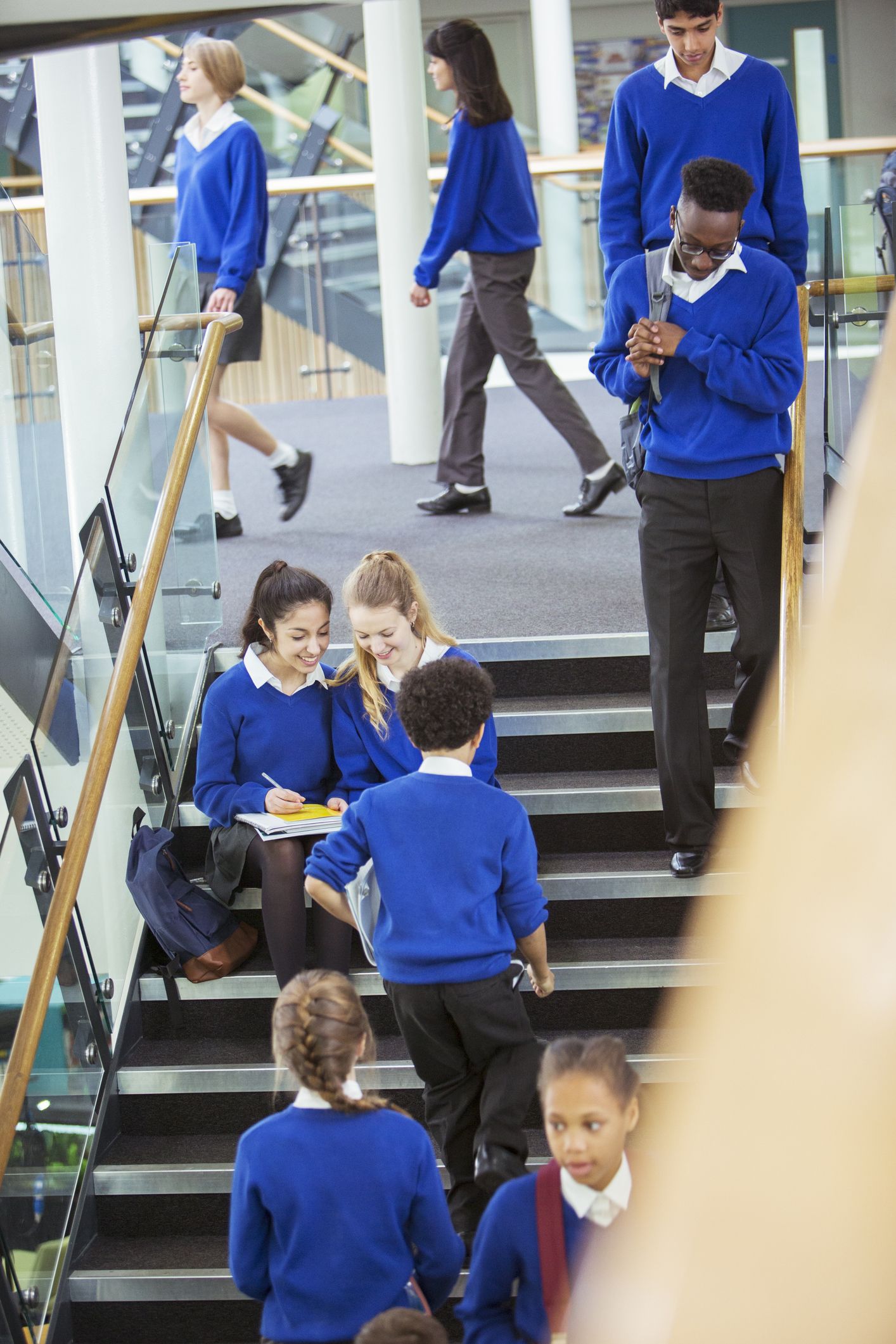 school students working in the school corridor and wearing blue school uniforms