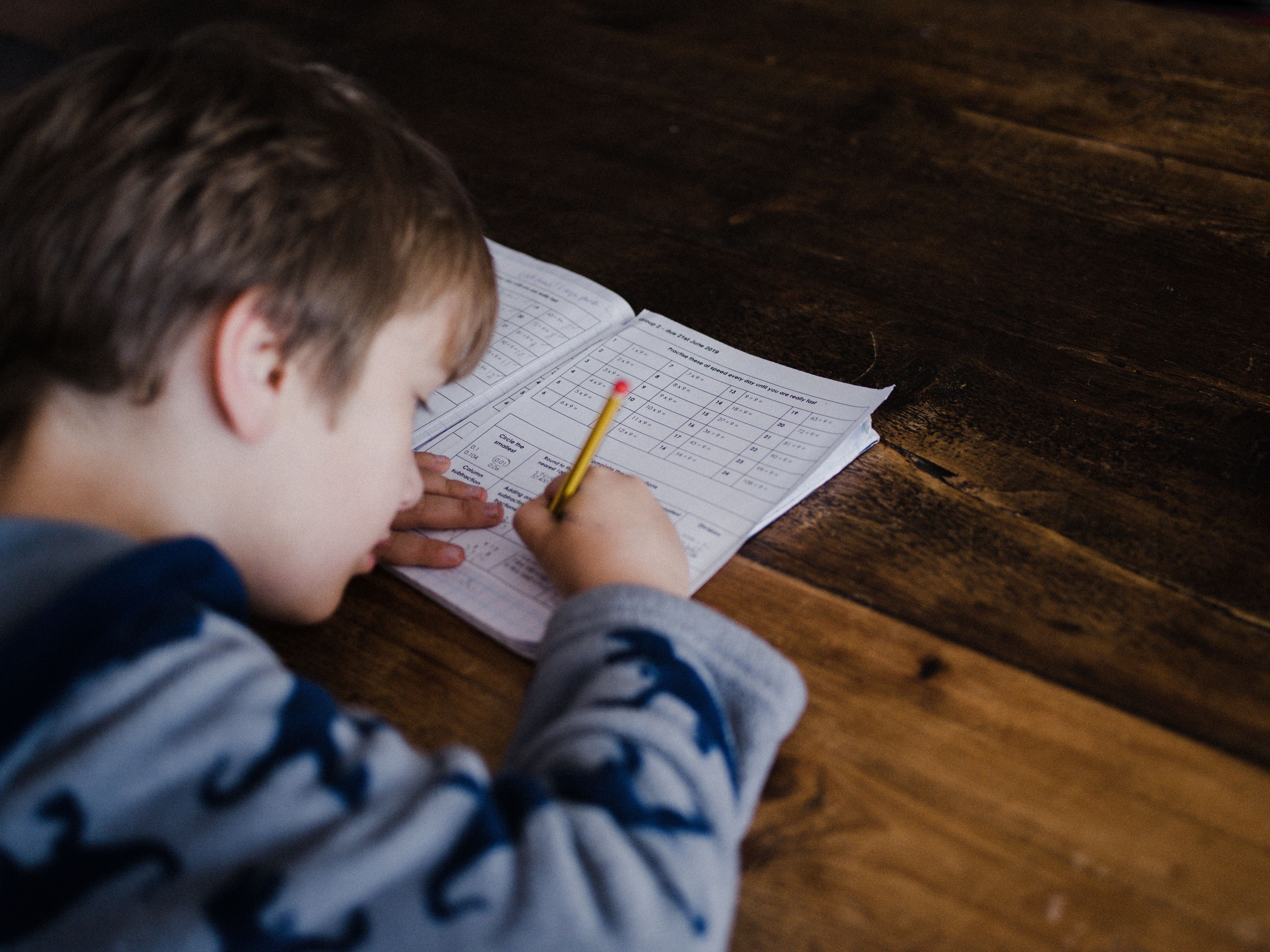 student writing in a workbook at a desk