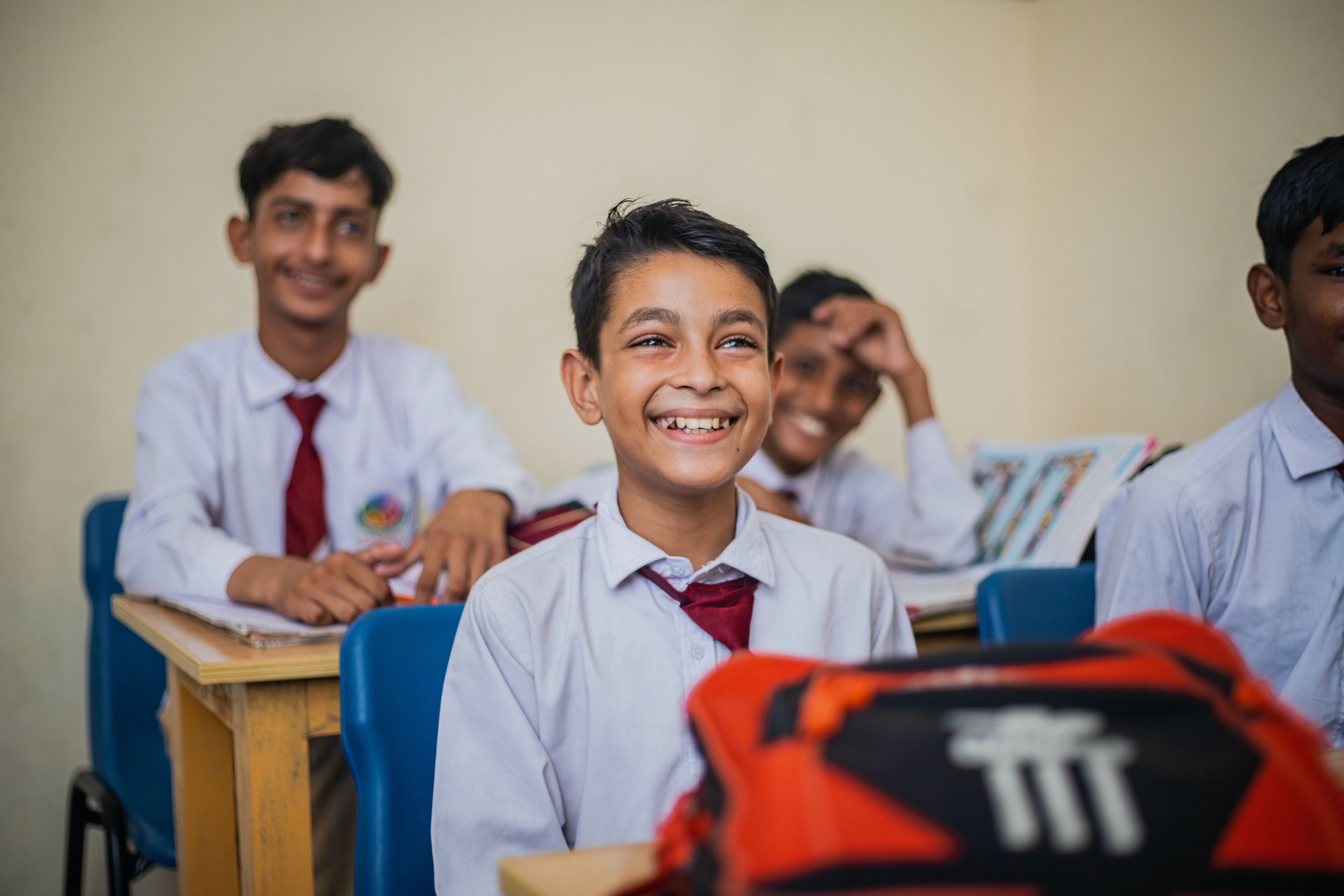a group of young men sitting at desks in a classroom